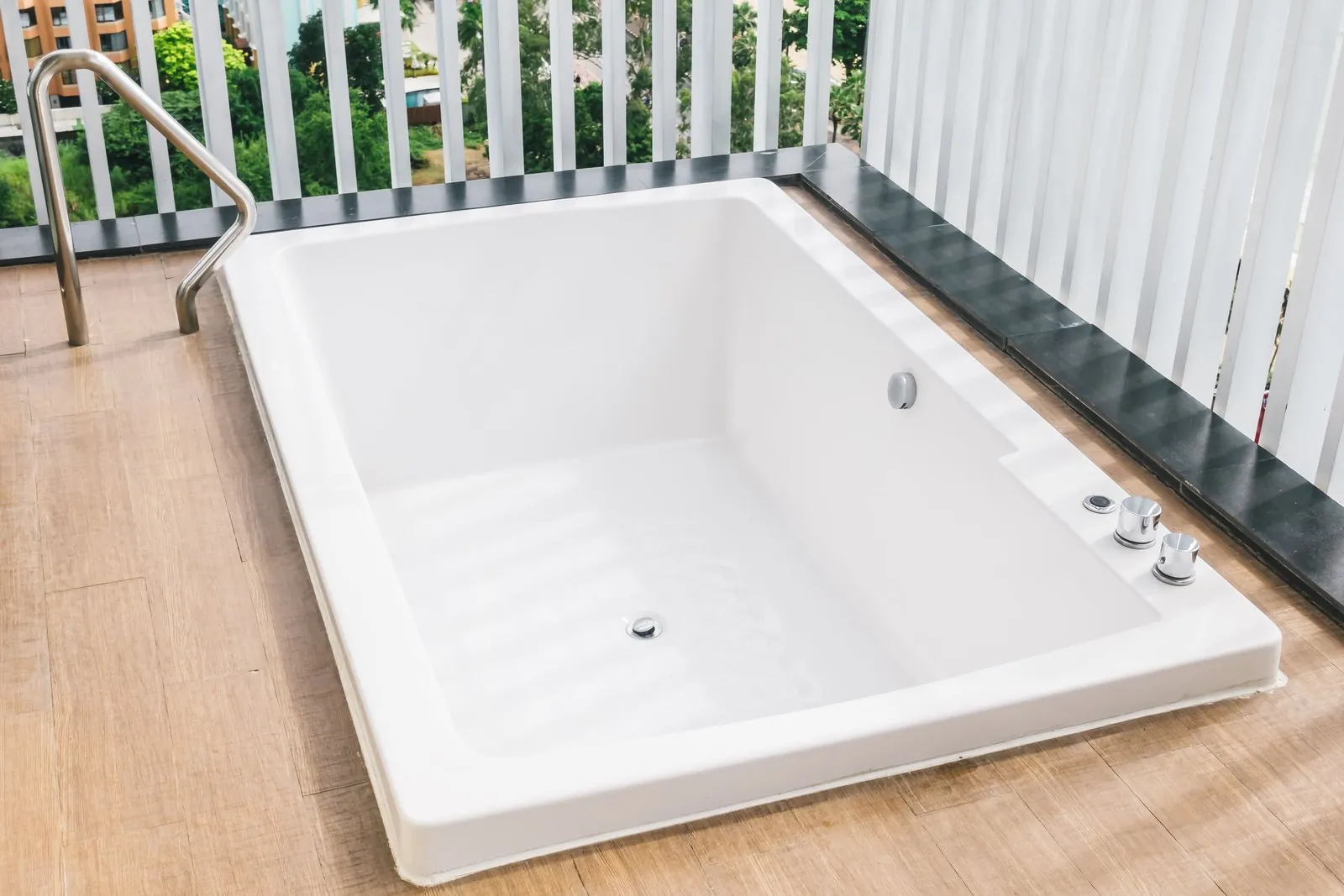 Baignoire rectangulaire blanche encastrée dans un sol en bois