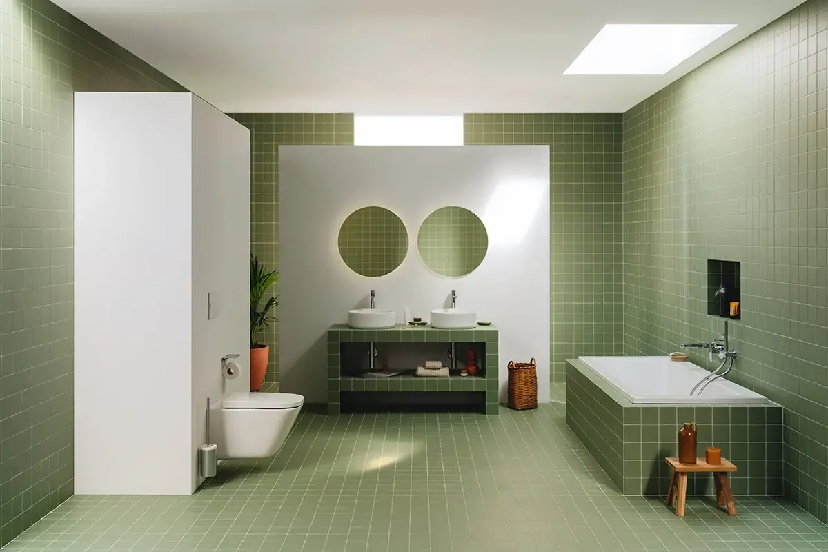 Grande salle de bain en carrelage vert avec baignoire maçonnée et double vasque