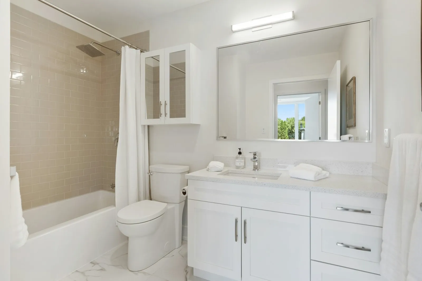 Baño blanco con bañera con cortina y mueble lavabo con cajones
