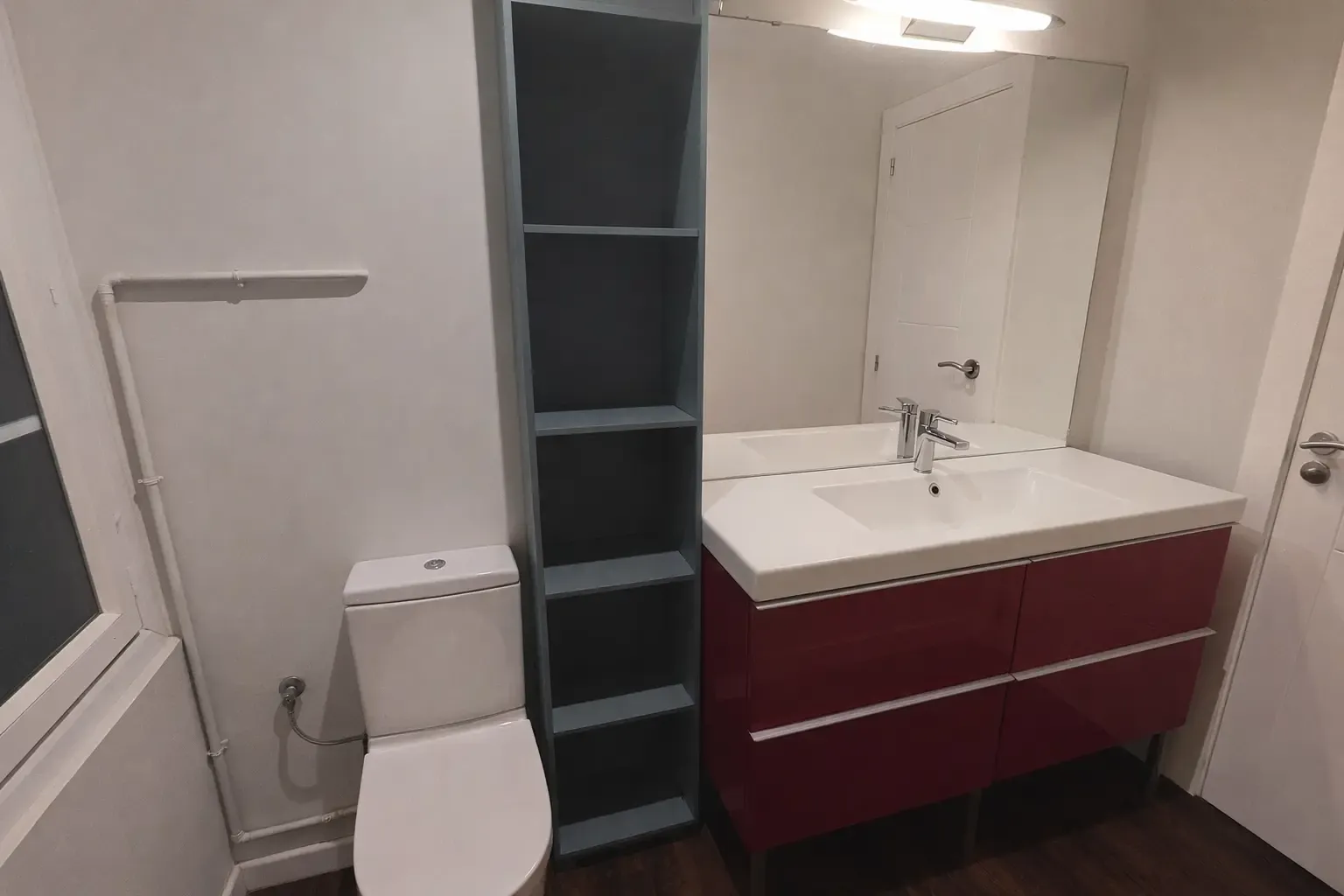 Mueble lavabo granate con columna verde e inodoro tras la reforma