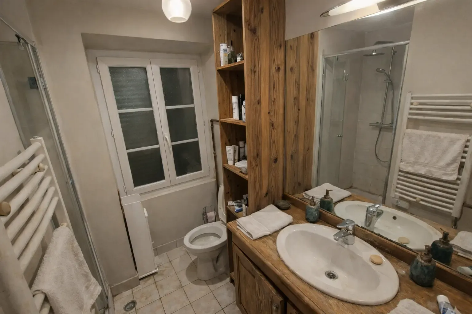 Baño pequeño antes de la reforma con mueble de madera y lavabo antiguo
