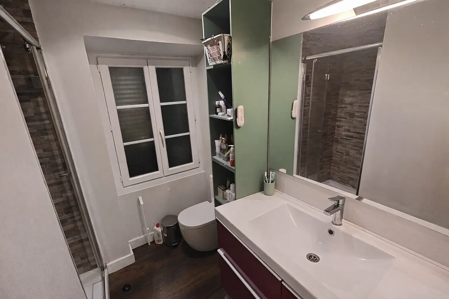 Baño pequeño reformado con mueble lavabo granate y pared verde